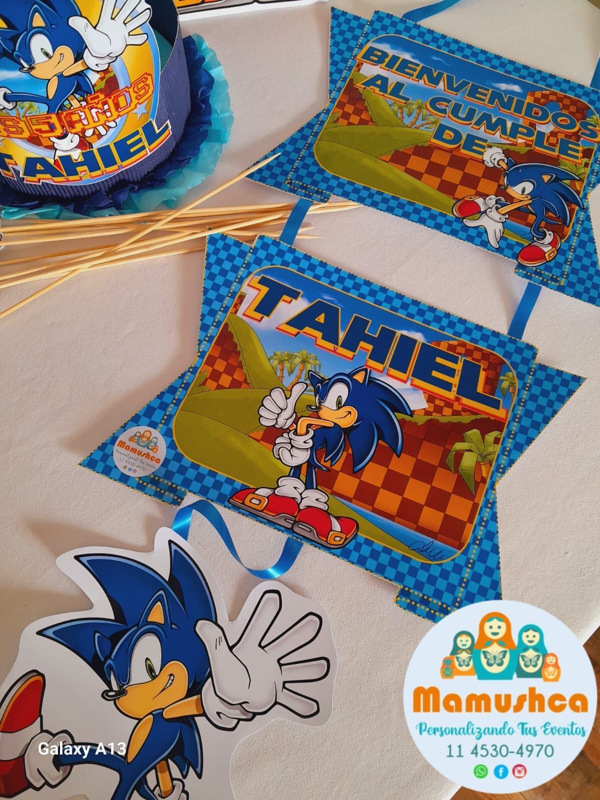 Decoraciones de cumpleaños con temática de Sonic the Hedgehog, que incluyen pancartas con el nombre "Tahiel" y una combinación de colores azul y blanco.