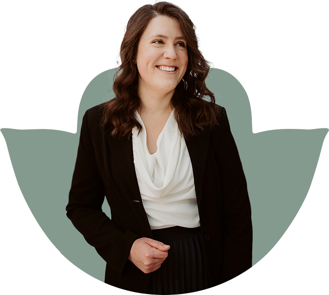 Woman in black blazer smiles, stands in front of a green cutout.