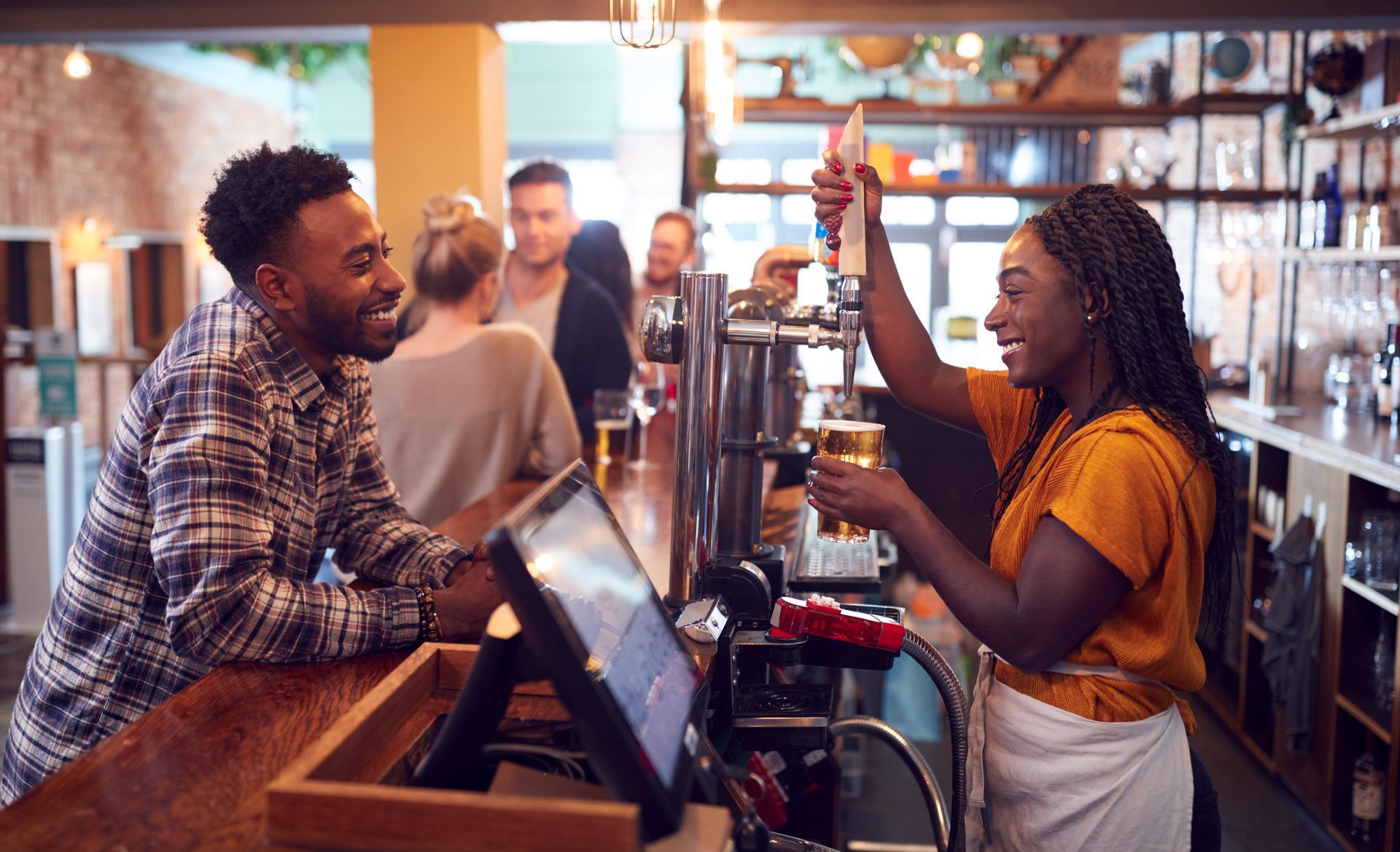 A man and a woman are giving each other a high five in a bar.