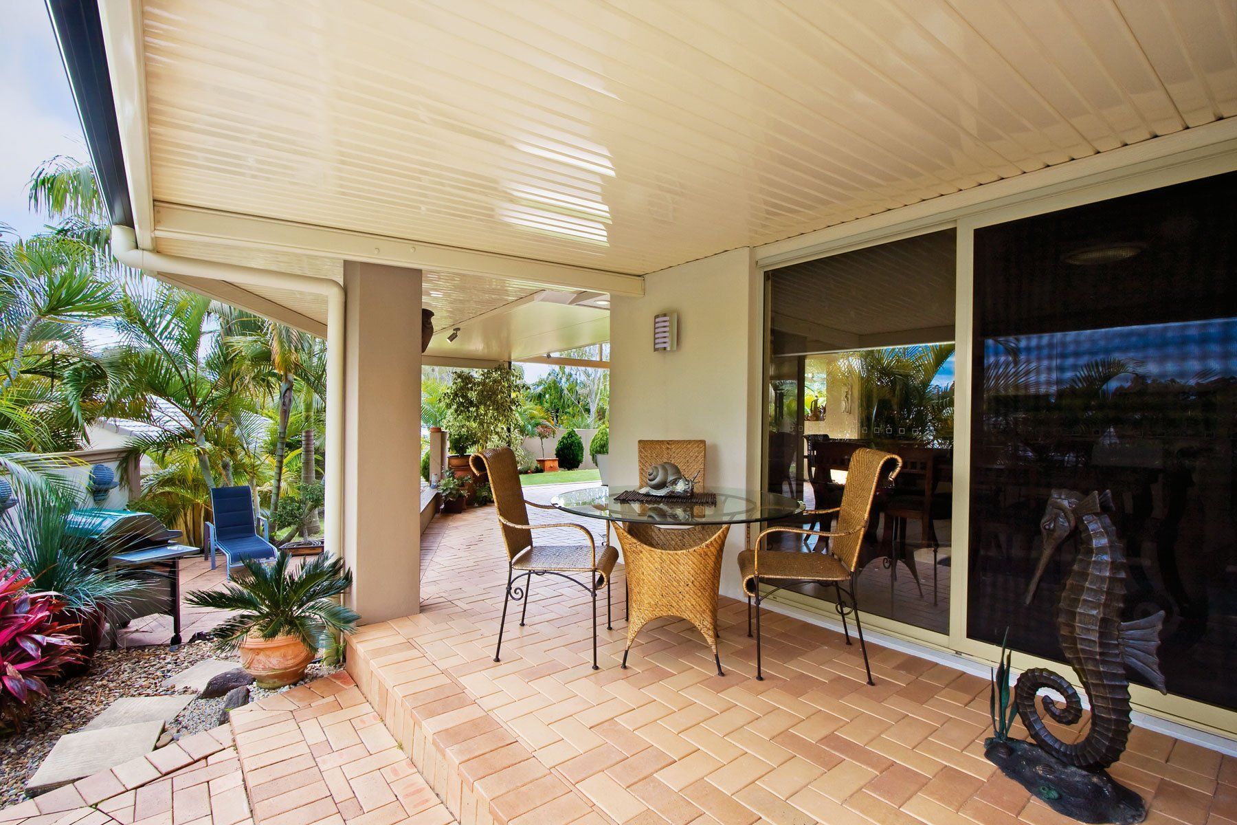Patio with A Table and Chairs, Overlooking a Garden — Precision Patios Toowoomba In Toowoomba, QLD