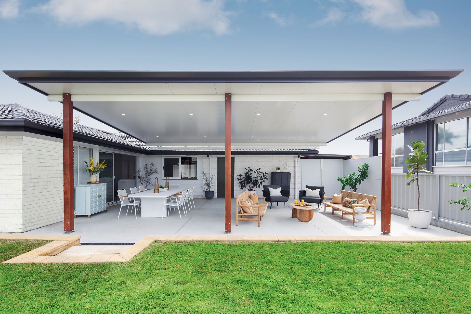 A Patio with Dining Set Under a Roof, Overlooking a Lawn — Precision Patios Toowoomba In Toowoomba, QLD