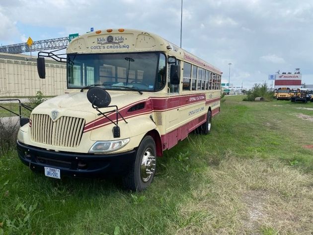 A school bus is parked in a grassy field.