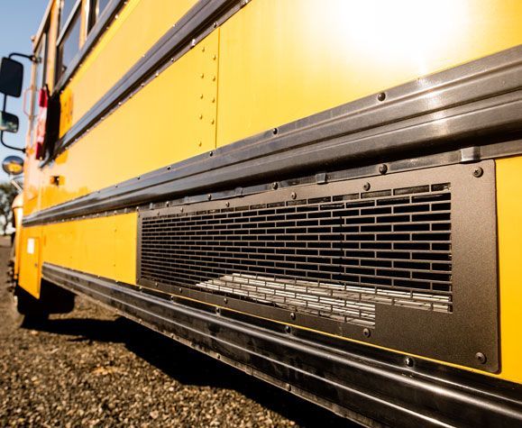 A close up of the side of a yellow school bus.