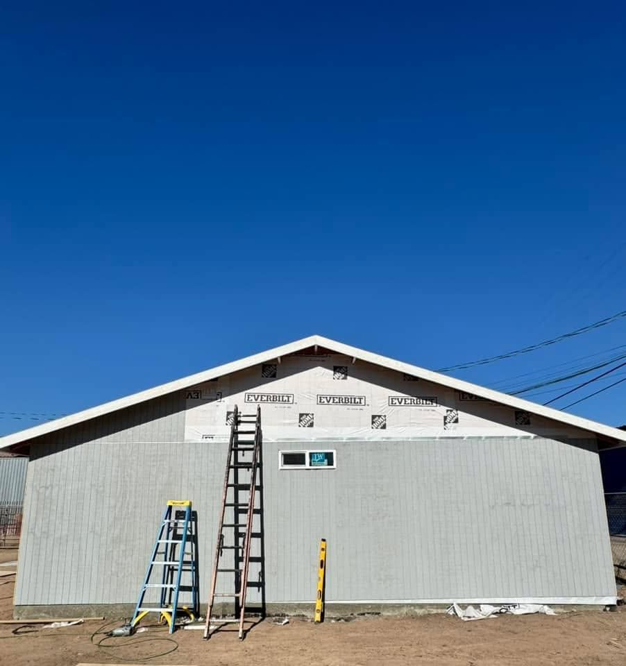 A ladder is sitting in front of a building under construction.