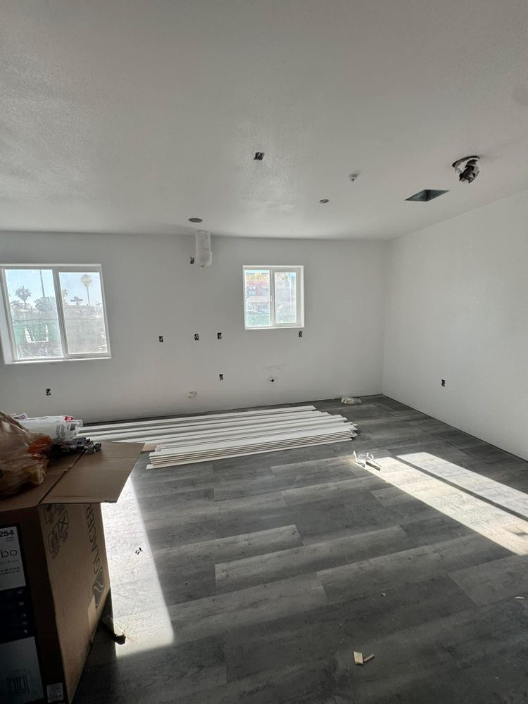 A large empty room with a wooden floor and white walls.