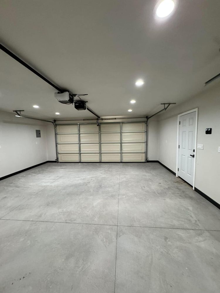 A large empty garage with a garage door open.