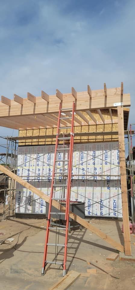 A ladder is sitting in front of a building under construction.