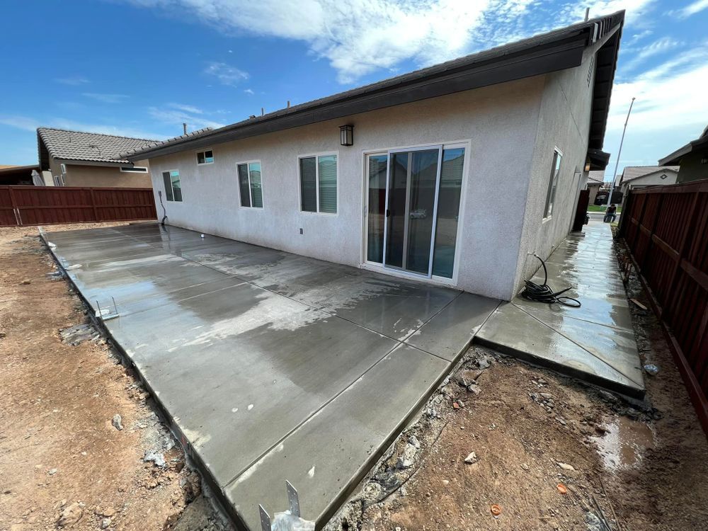 A concrete patio is being built in front of a house.