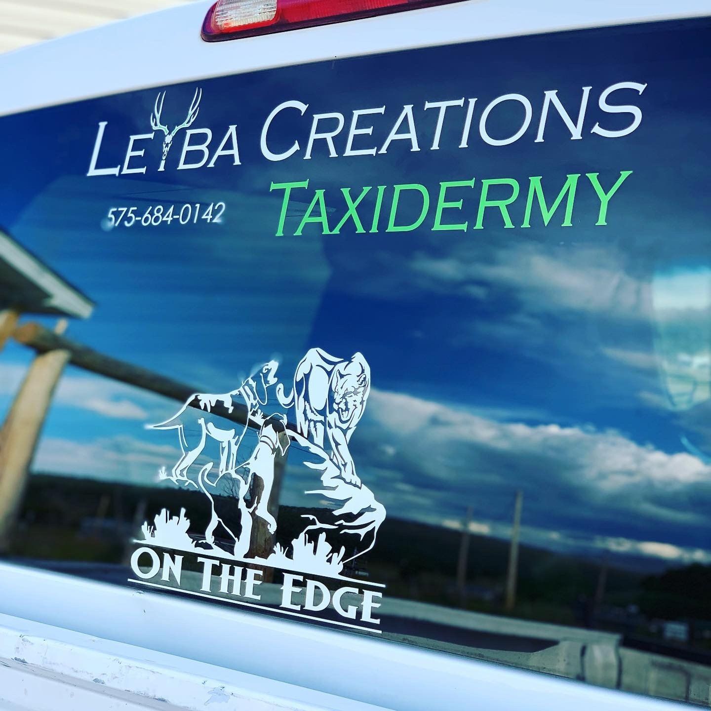 Leyba creations taxidermy is advertised on the back window of a truck