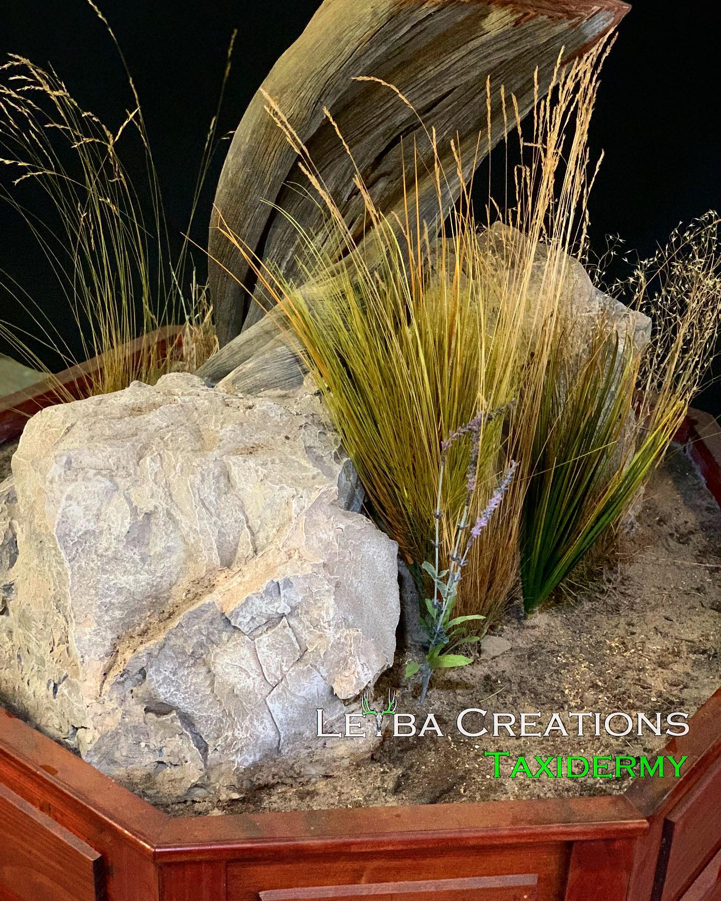 A wooden planter filled with rocks and grass.