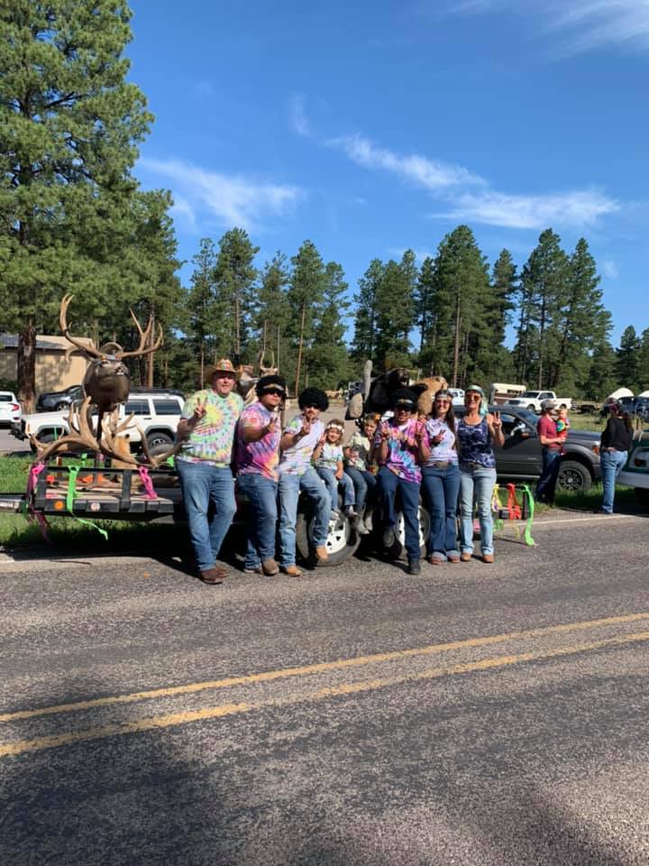 A group of people standing on the side of a road next to a wagon.