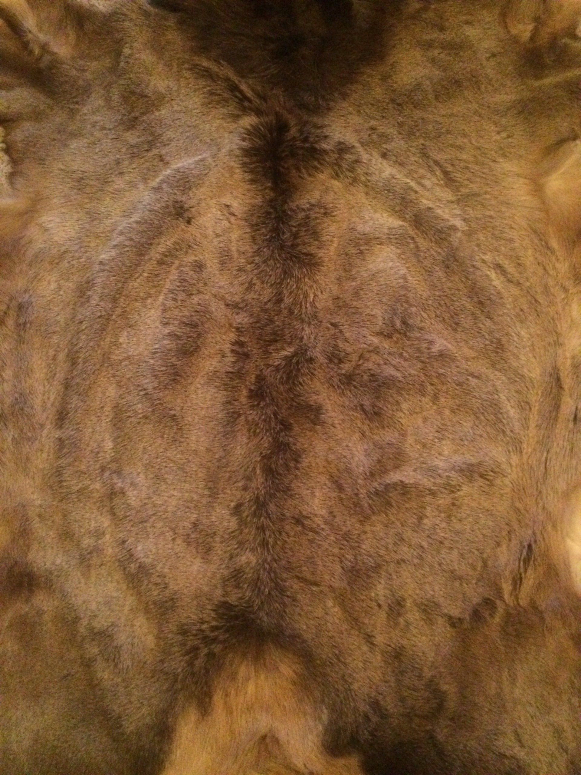 A close up of a brown fur rug on a table.