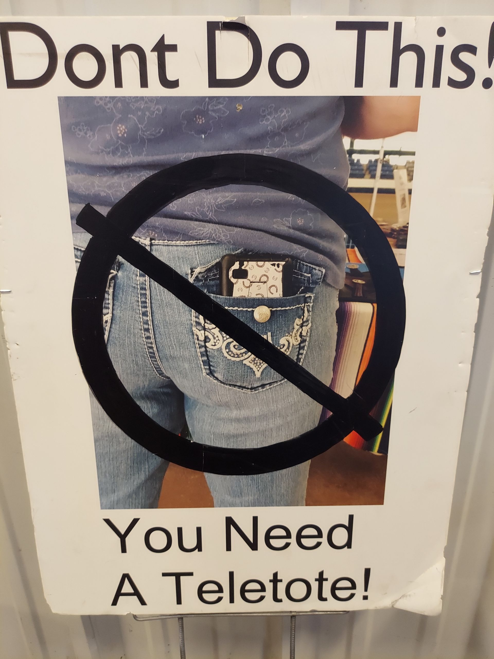 A sign shows a smartphone in a back pocket with a 