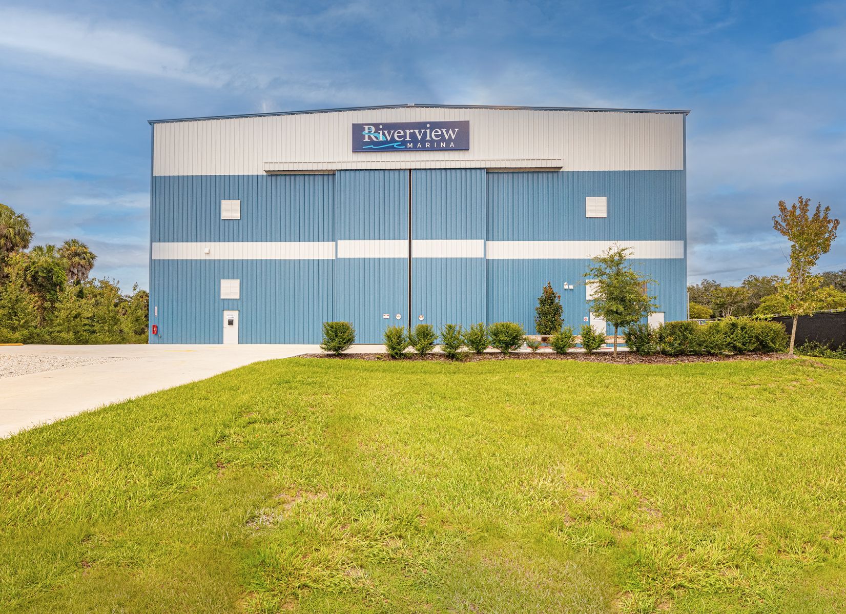 A large blue and white building with a large sliding door at Riverview Marina.