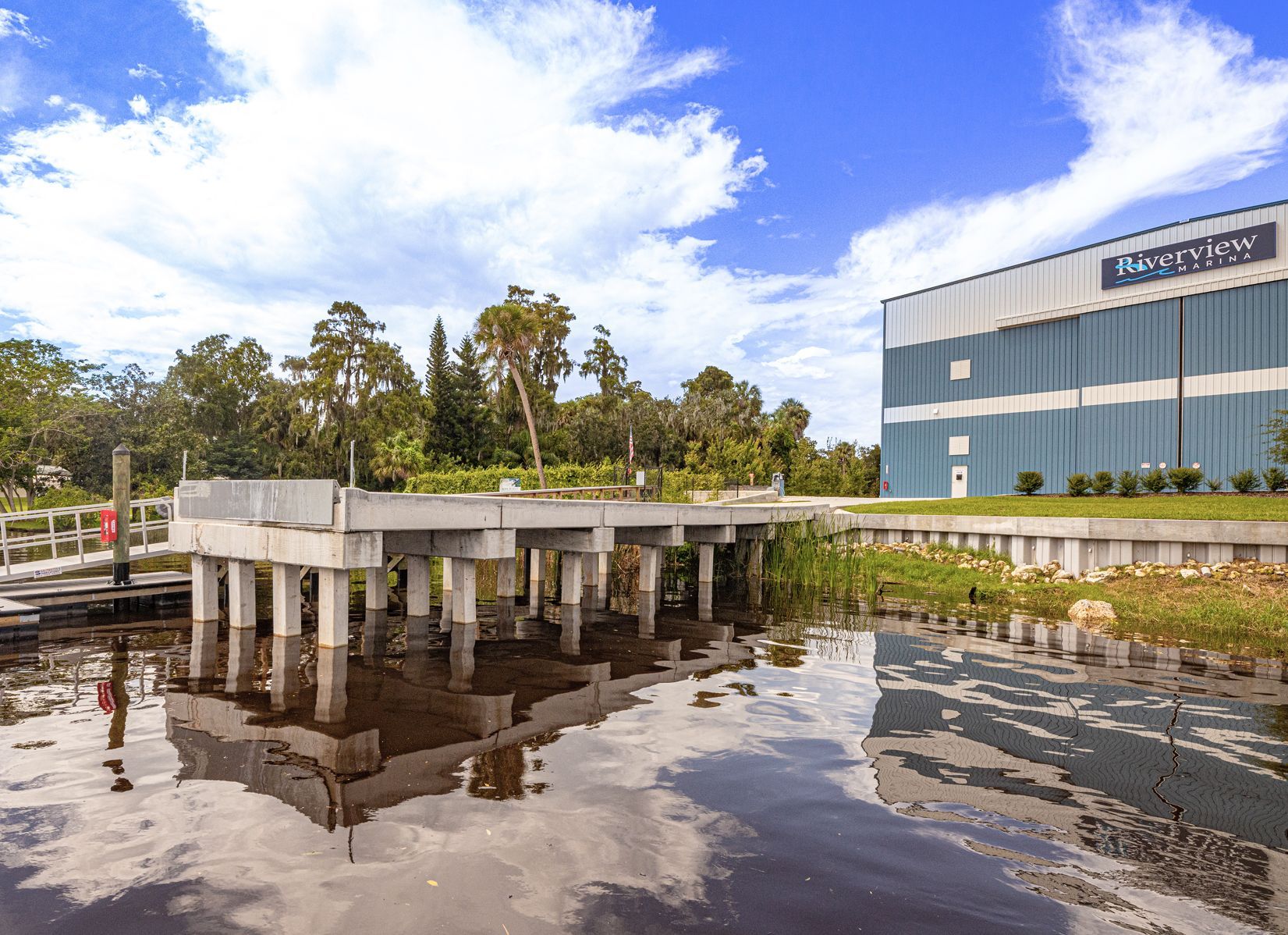 A bridge over a body of water with a building in the background at Riverview Marina