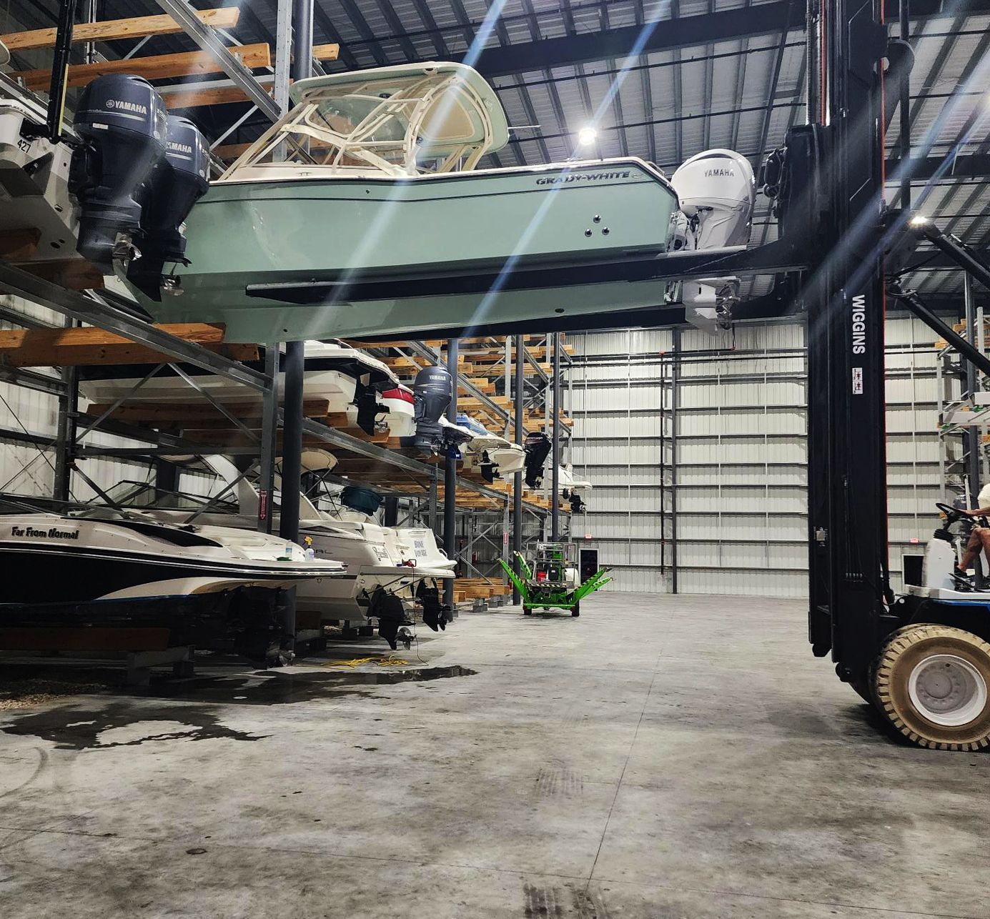 A forklift is lifting a boat in a warehouse at Riverview Marina