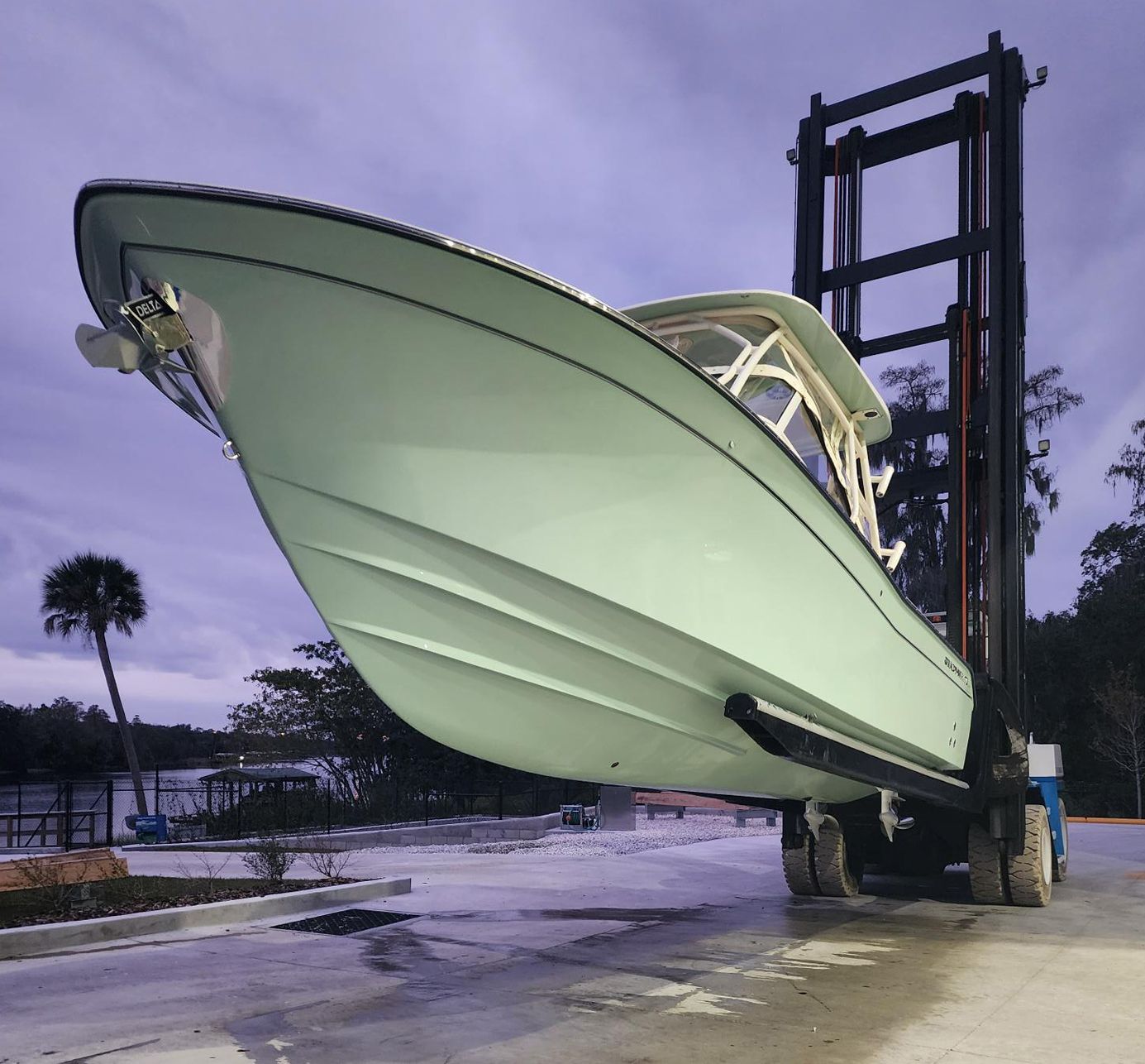 A large boat is being lifted by a forklift at Riverview Marina