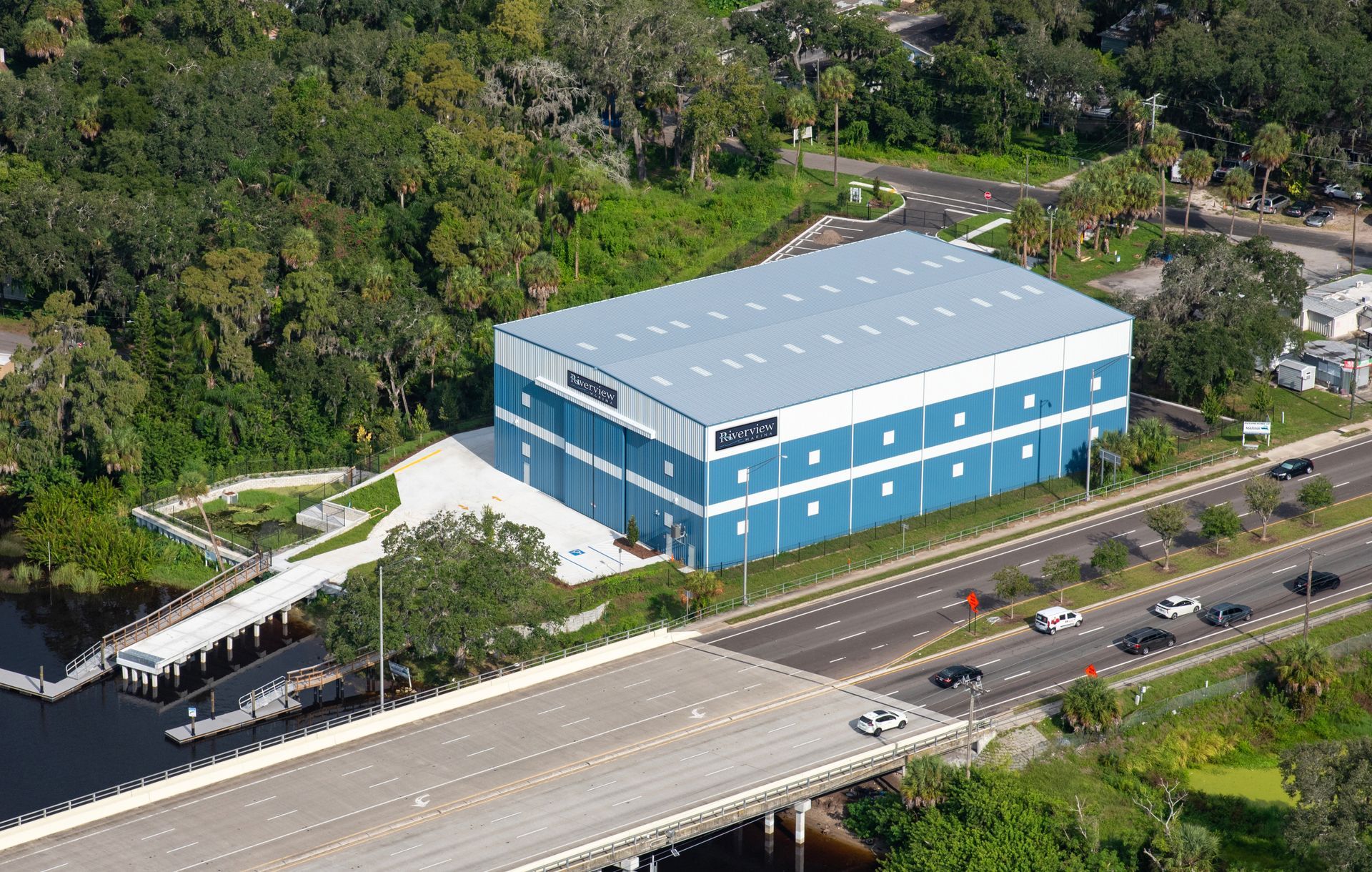 An aerial view of a large Riverview Marina boat storage building next to a highway.