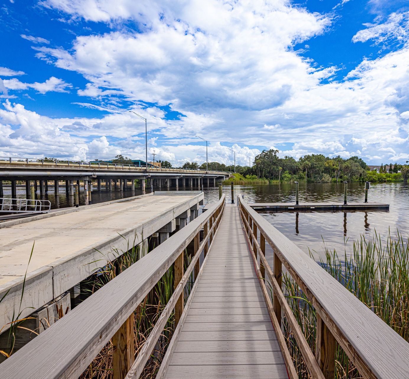A wooden walkway leading to a bridge over a body of water at Riverview Marina