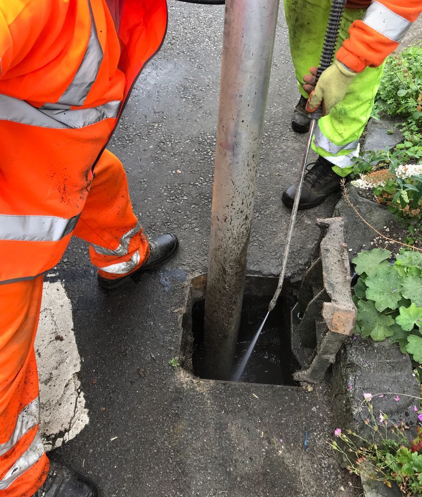 Workers in Vests Clean a Metal Pole Base — Mi Plumber Wagga Wagga in Lake Albert, NSW