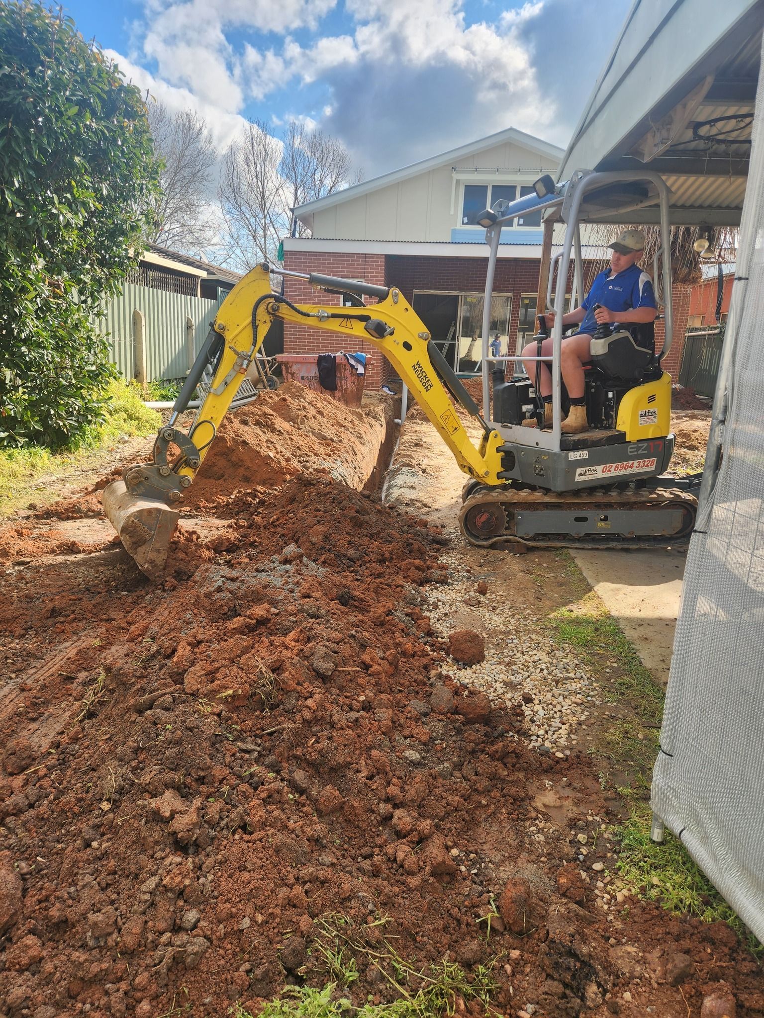 A Person Operates a Yellow Mini Excavator — Mi Plumber Wagga Wagga in Young, NSW