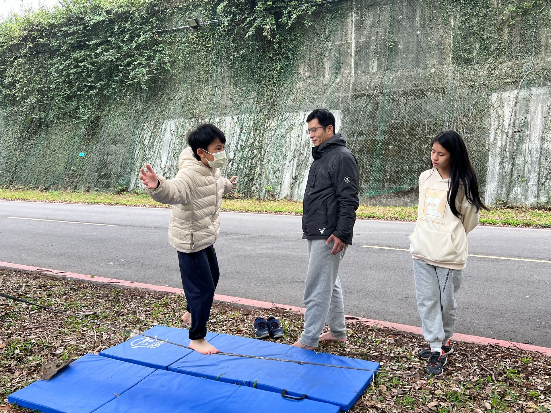 A group of people are standing on top of a blue mat.