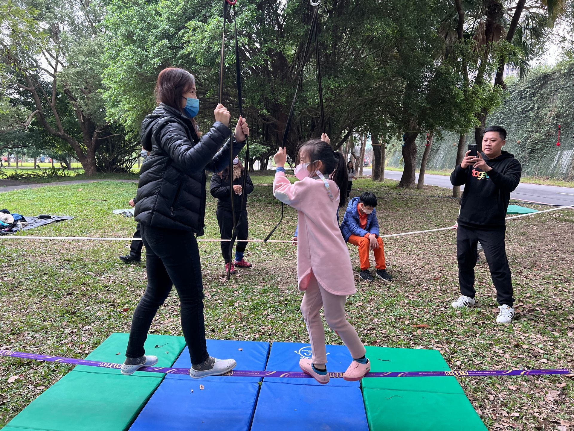 A group of people are playing a game in a park.