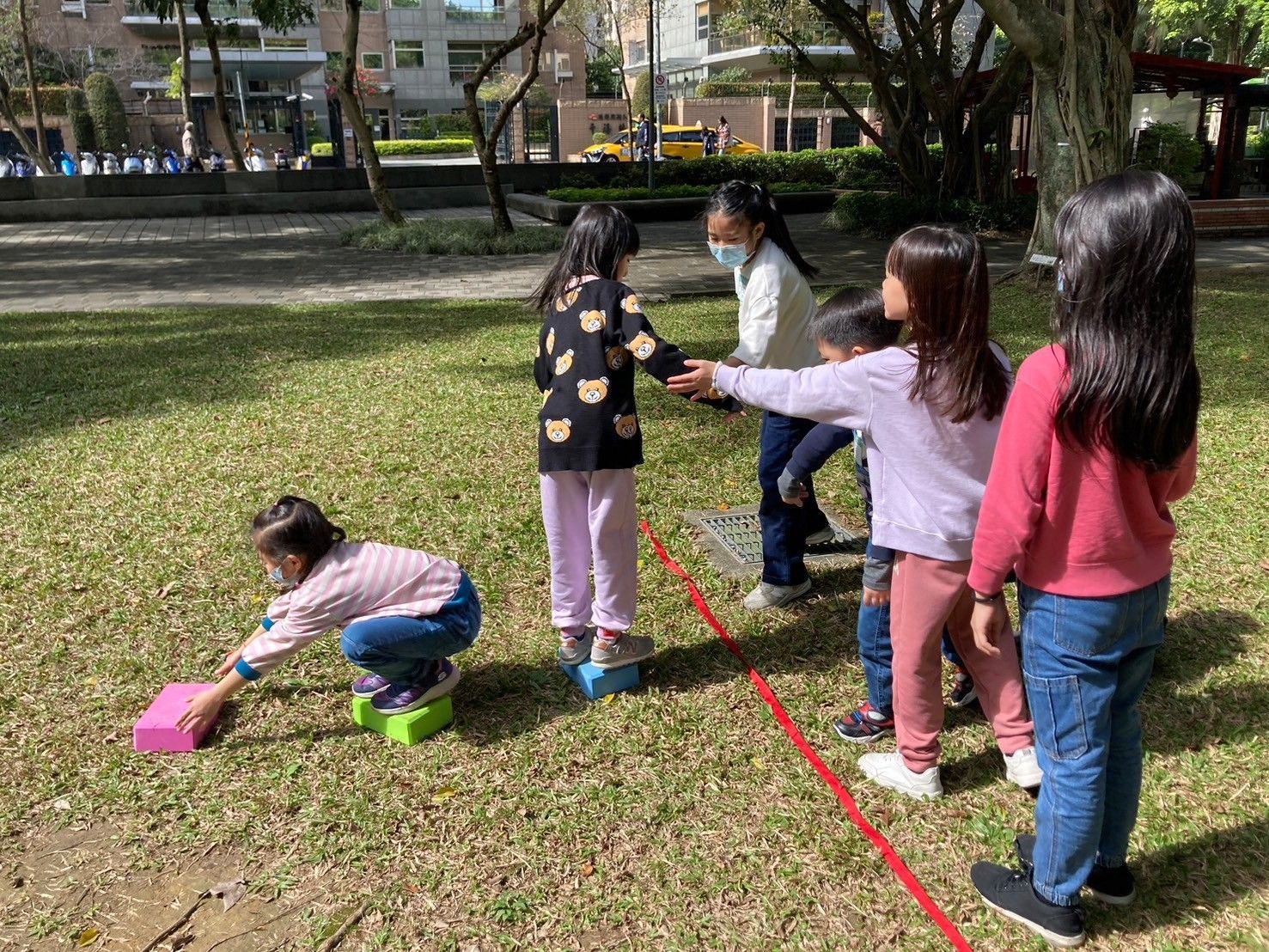 A group of children are playing a game in a park.