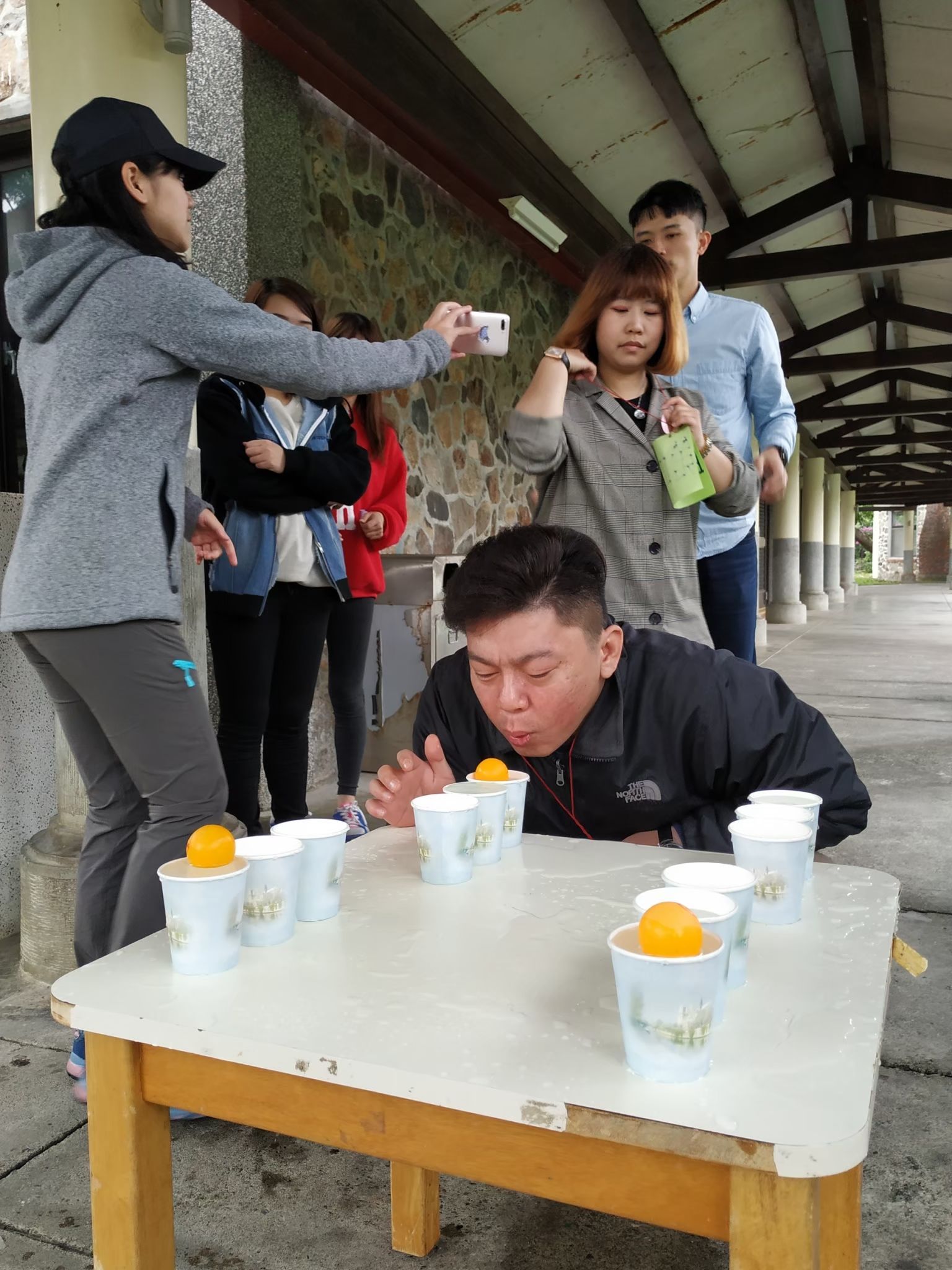 A group of people are playing a game of beer pong on a table.