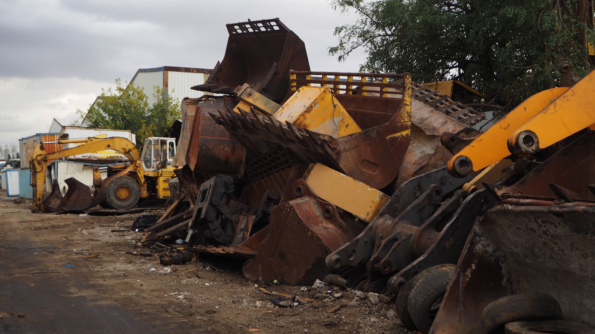 Woman in straw hat smiles, holding wine glass near a lake.