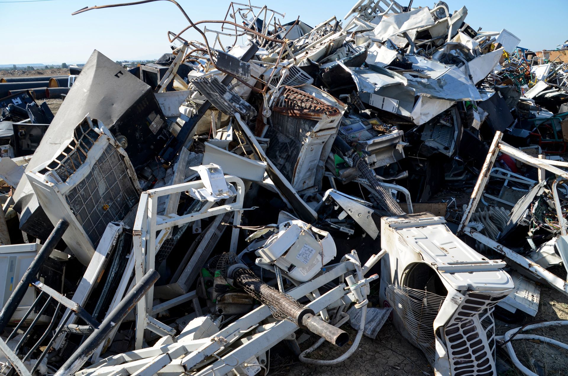 Woman in straw hat smiles, holding wine glass near a lake.