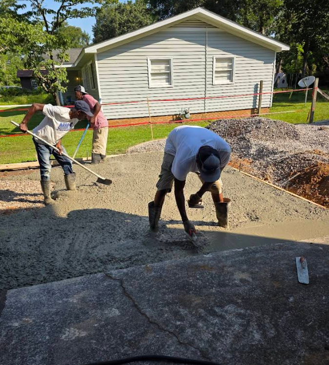 Repairing a concrete wall with a trowel and cement, showing rebar reinforcement.
