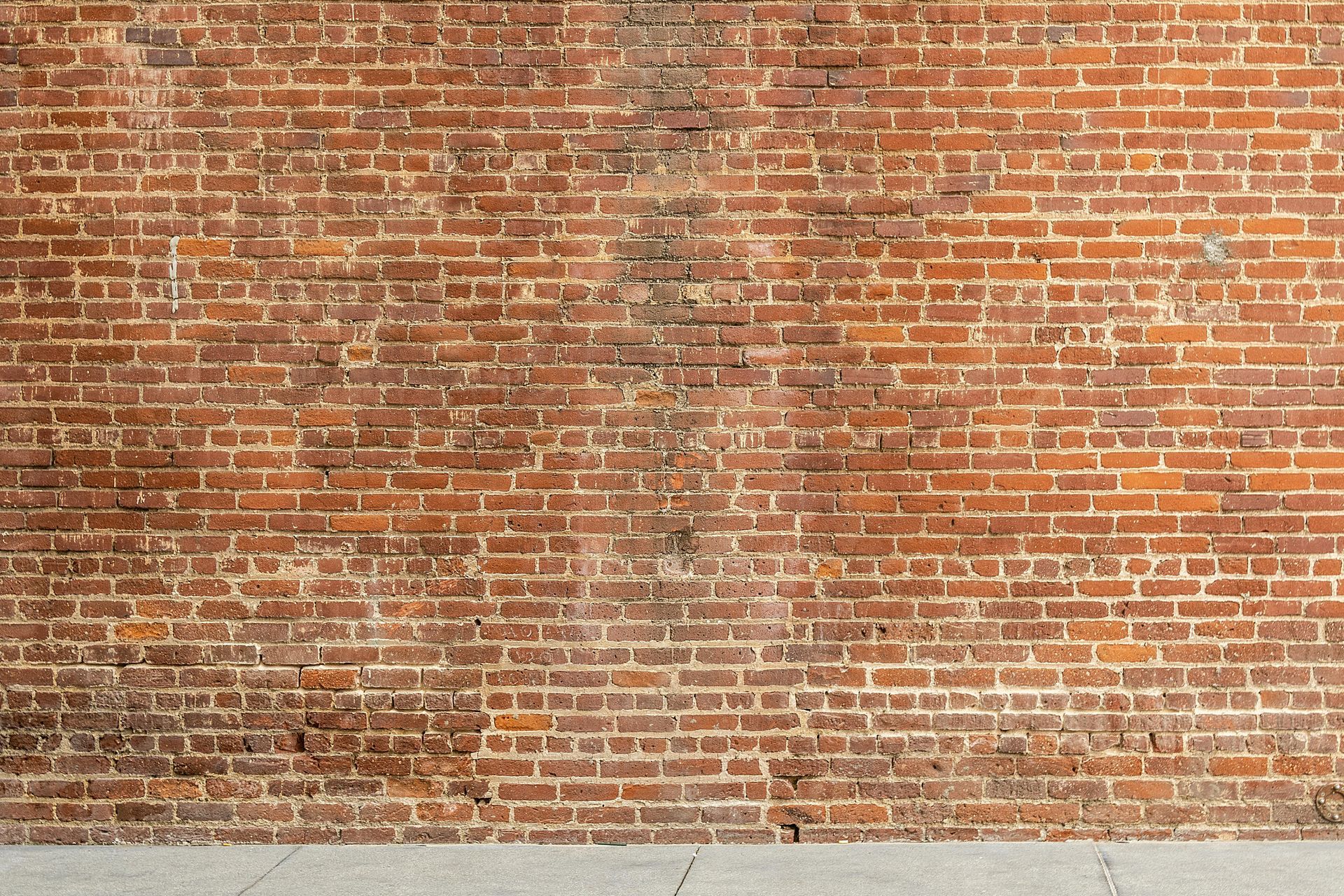 Red brick wall with a concrete base.