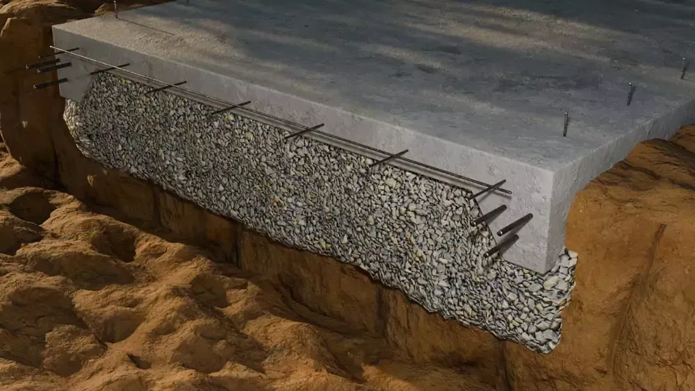 Cutaway view of concrete bridge construction, showing rebar embedded in concrete and gravel base.
