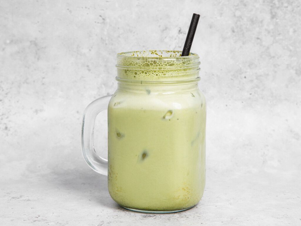 Iced matcha latte in a mason jar with a straw.