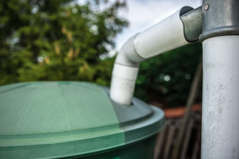 A Close up Of a Rain Barrel with A Pipe — Origin Plumbing & Gas in Tuckurimba, NSW