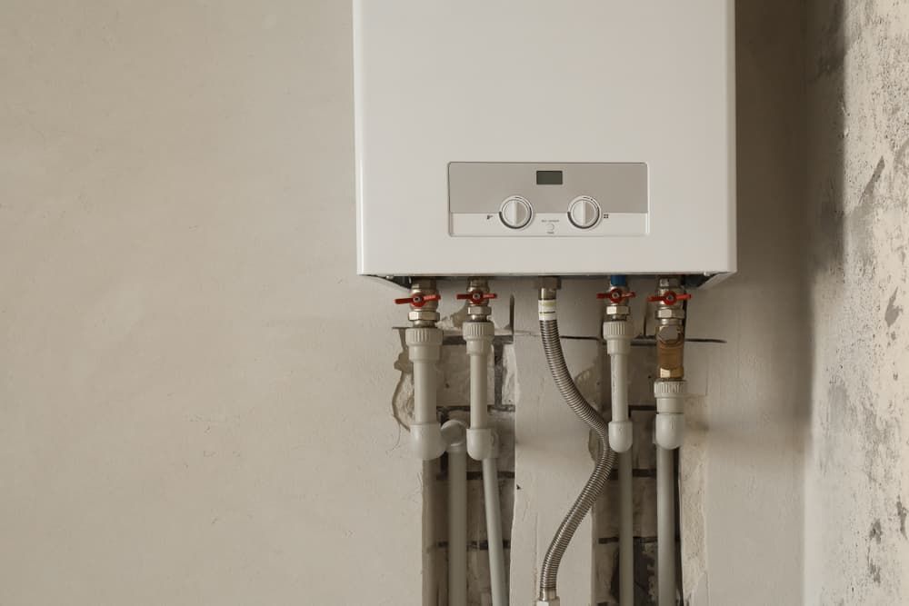 A White Boiler with Pipes Attached — Origin Plumbing & Gas in Tuckurimba, NSW