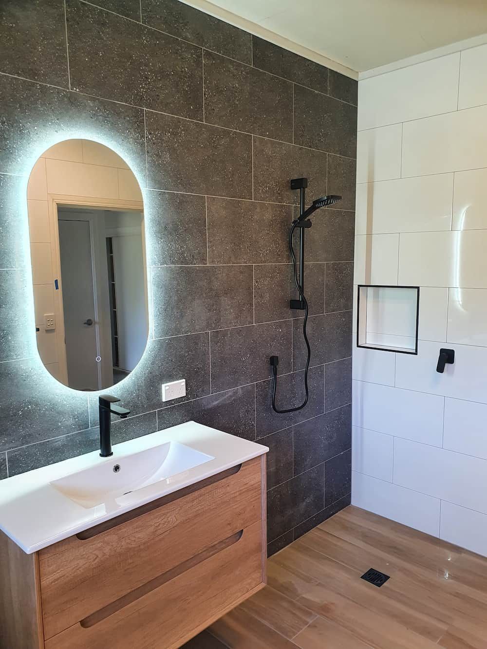 A Bathroom with A Sink, Mirror and Shower — Origin Plumbing & Gas in Tuckurimba, NSW