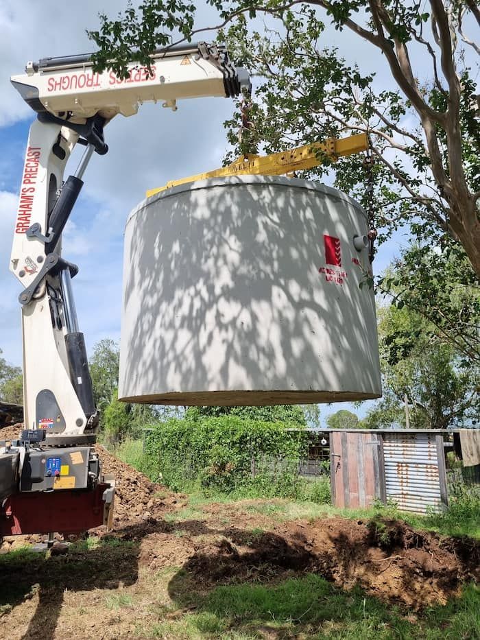 A Large Concrete Cylinder Is Being Lifted by A Crane — Origin Plumbing & Gas in Tuckurimba, NSW