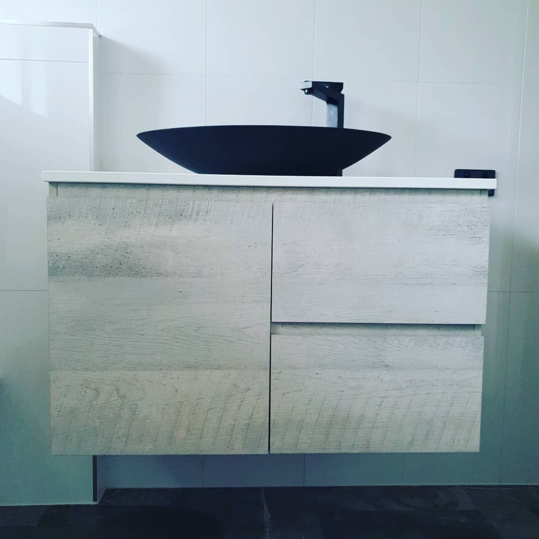 A Bathroom Vanity with A Black Sink on Top of It — Origin Plumbing & Gas in Tuckurimba, NSW