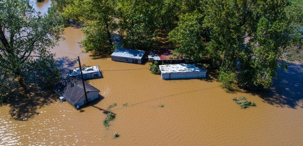 An Aerial View of A Flooded Area with Houses and Trees — Origin Plumbing & Gas in Tuckurimba, NSW
