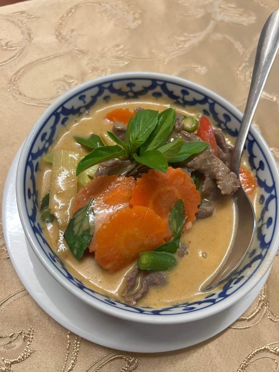 A Bowl of Soup With Meat and Vegetables and a Spoon in It — Thai Taste Restaurant In Gracemere, QLD