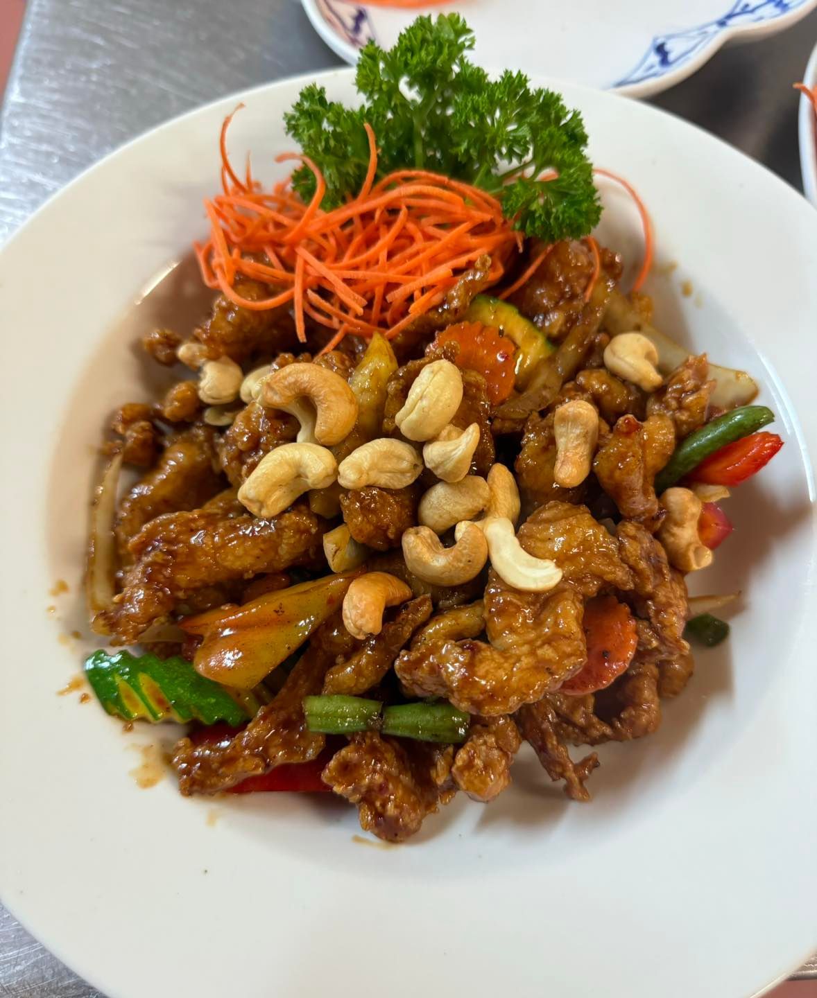 A White Plate Topped With Meat, Vegetables and Cashews — Thai Taste Restaurant In Norman Gardens, QLD