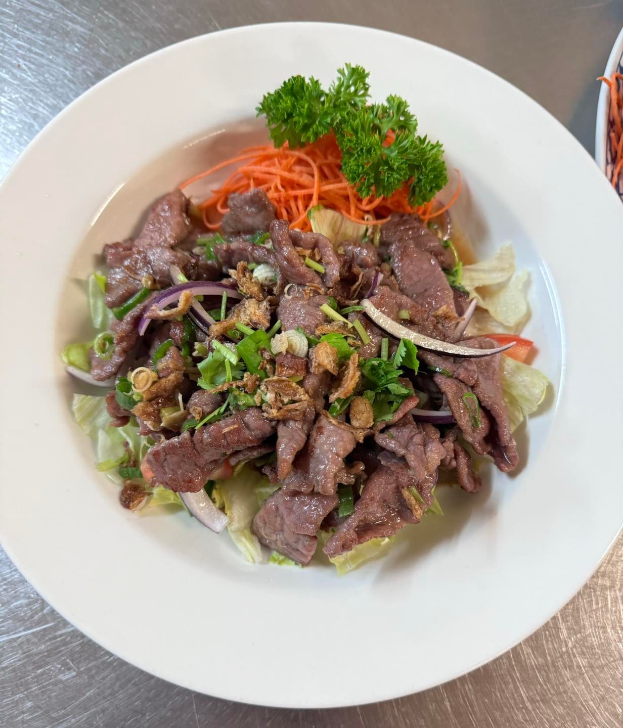A White Plate Topped With Meat and Vegetables on a Table — Thai Taste Restaurant In Yeppoon, QLD