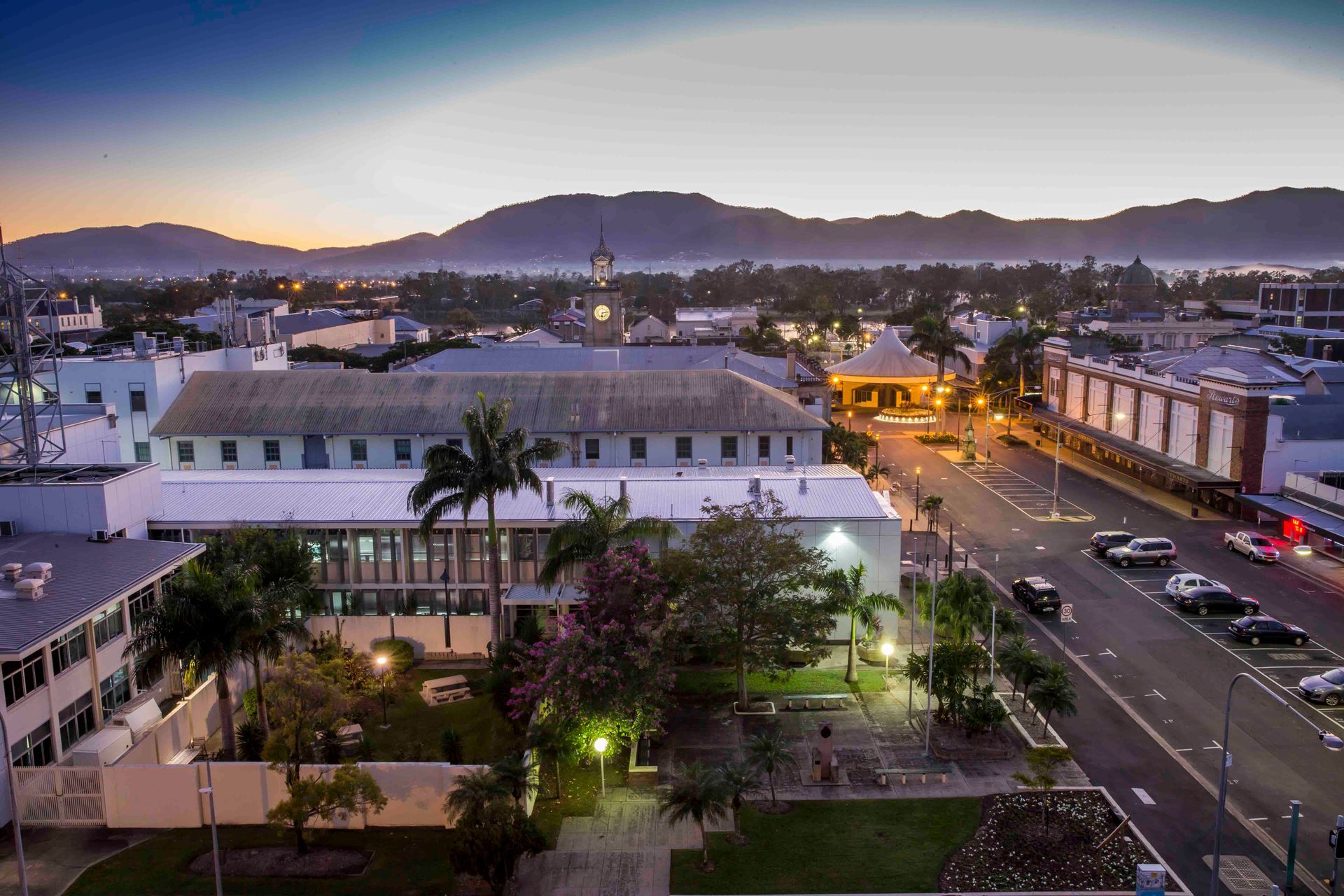 An Aerial View of a City at Night With Mountains in the Background — Thai Taste Restaurant In Gracemere, QLD