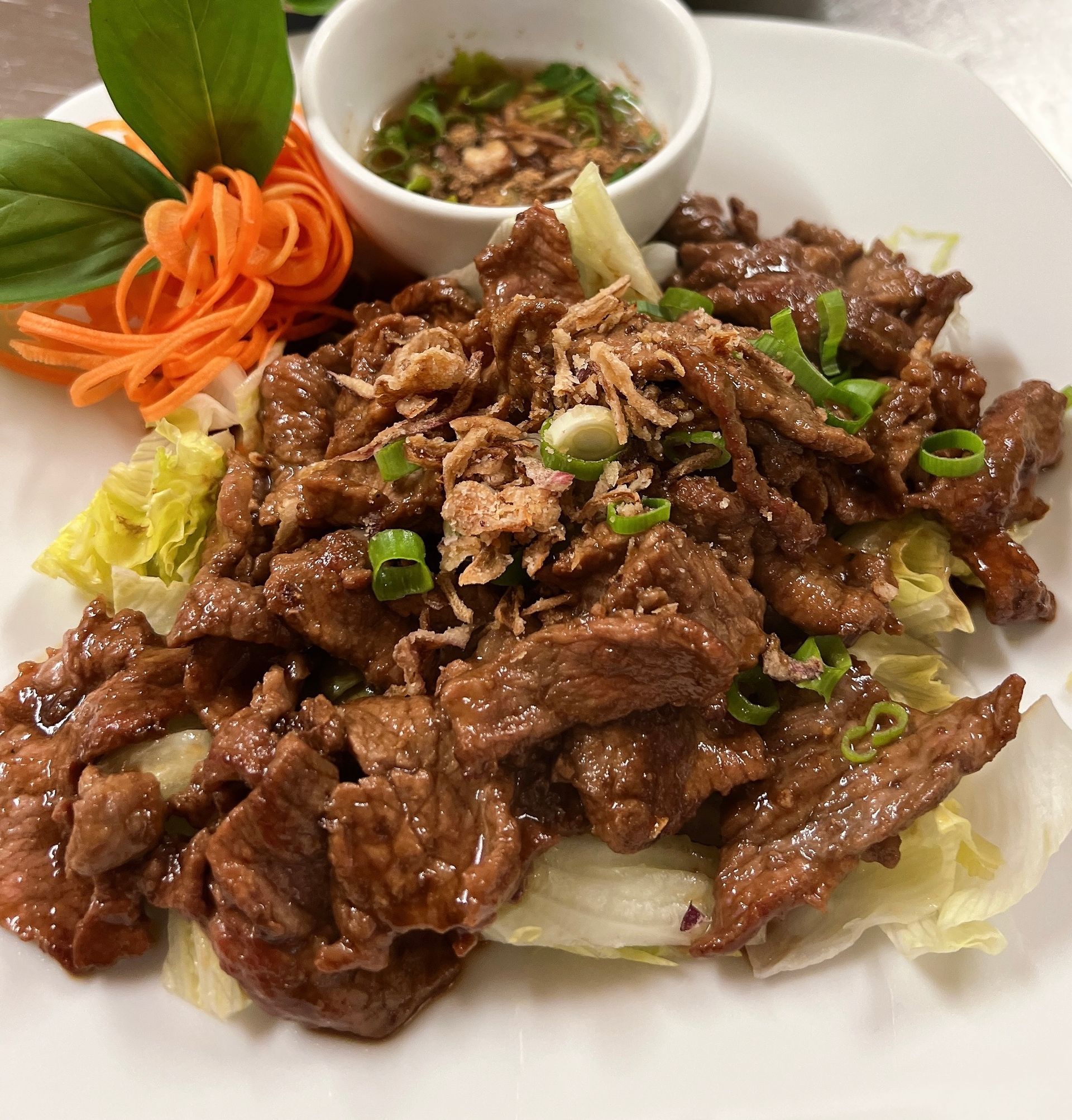 A Close Up of a Plate of Food With Meat and Vegetables on a Table — Thai Taste Restaurant In Norman Gardens, QLD
