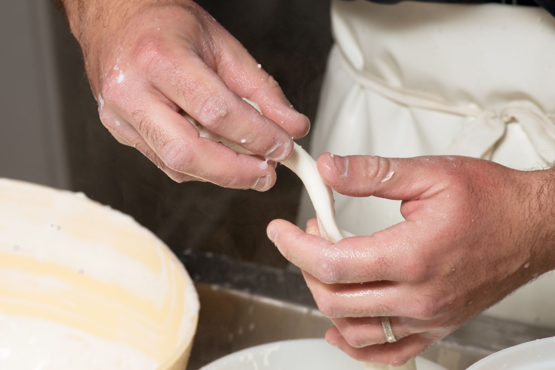 Una persona tiene in mano un pezzo di formaggio.