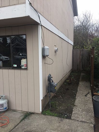 A house with a window and a hose on the side of it.