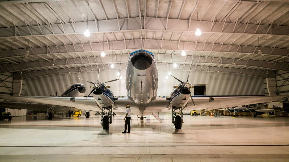 A large airplane is parked inside of a hangar.