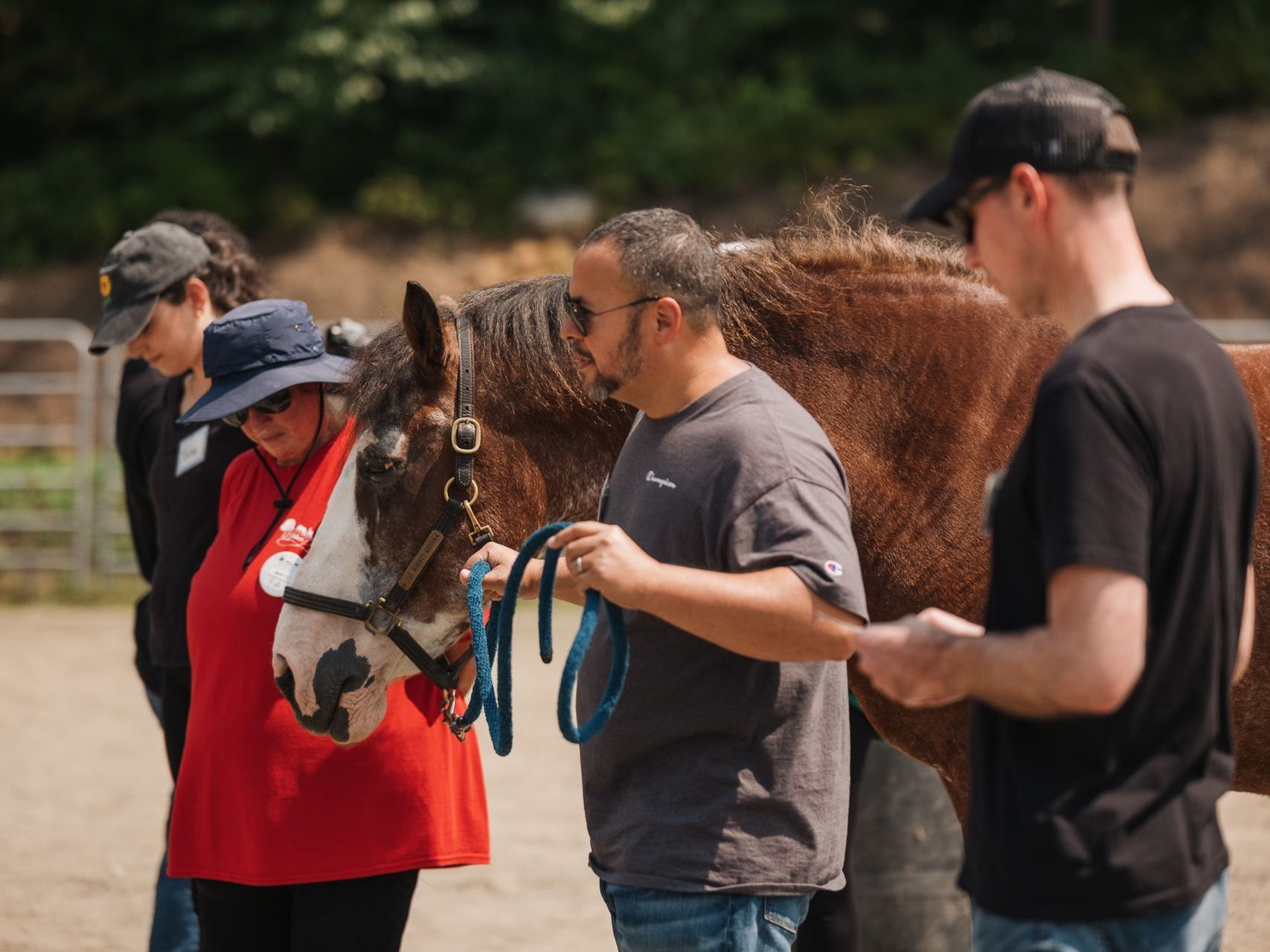 A woman is standing next to a child riding a horse